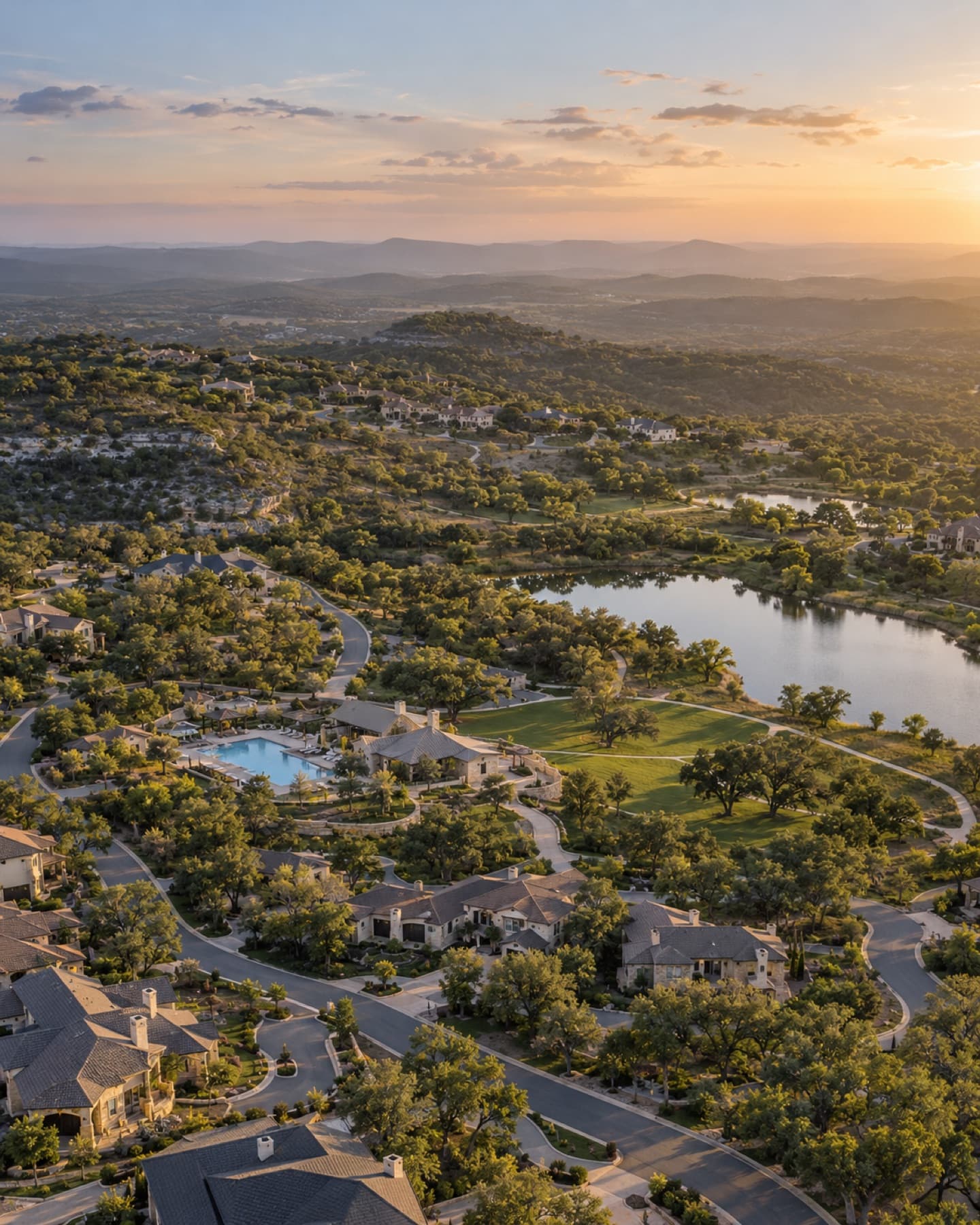 Aerial view of a Hill Country community with homes, a pool, a park and a pond